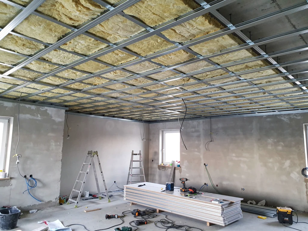 Faux plafond suspendu isolé en cours de pose sur ossature métallique